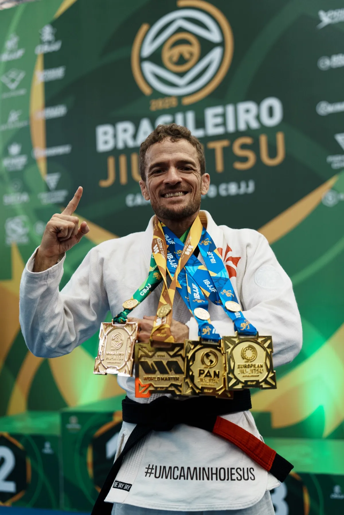 Sensei Raul Gomes sorrindo e comemorando com as medalhas de Brasileiro, World Master, Pan e Europeu